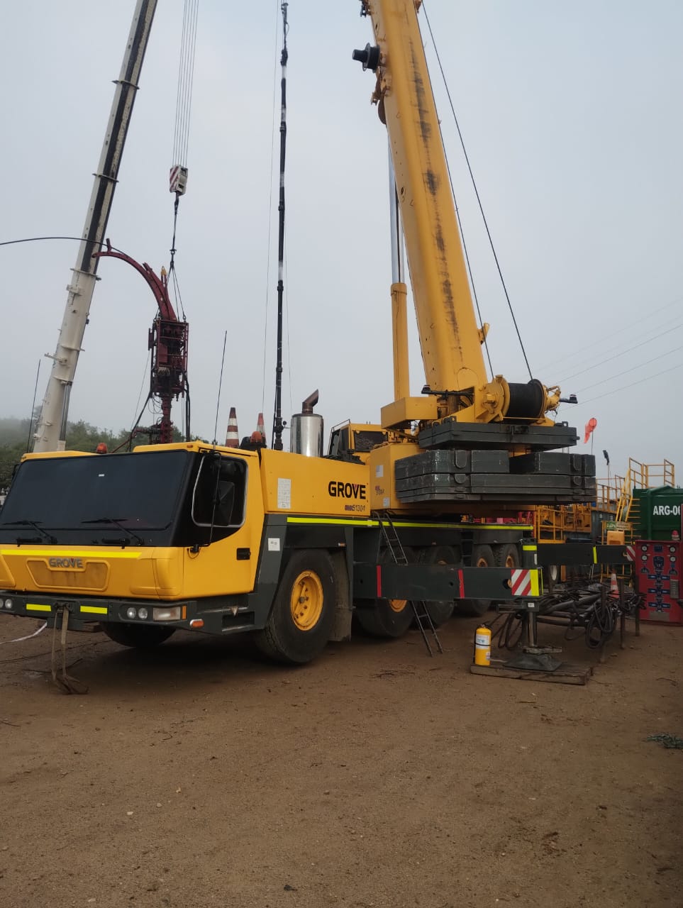 Grúa articulada manejando tanque industrial