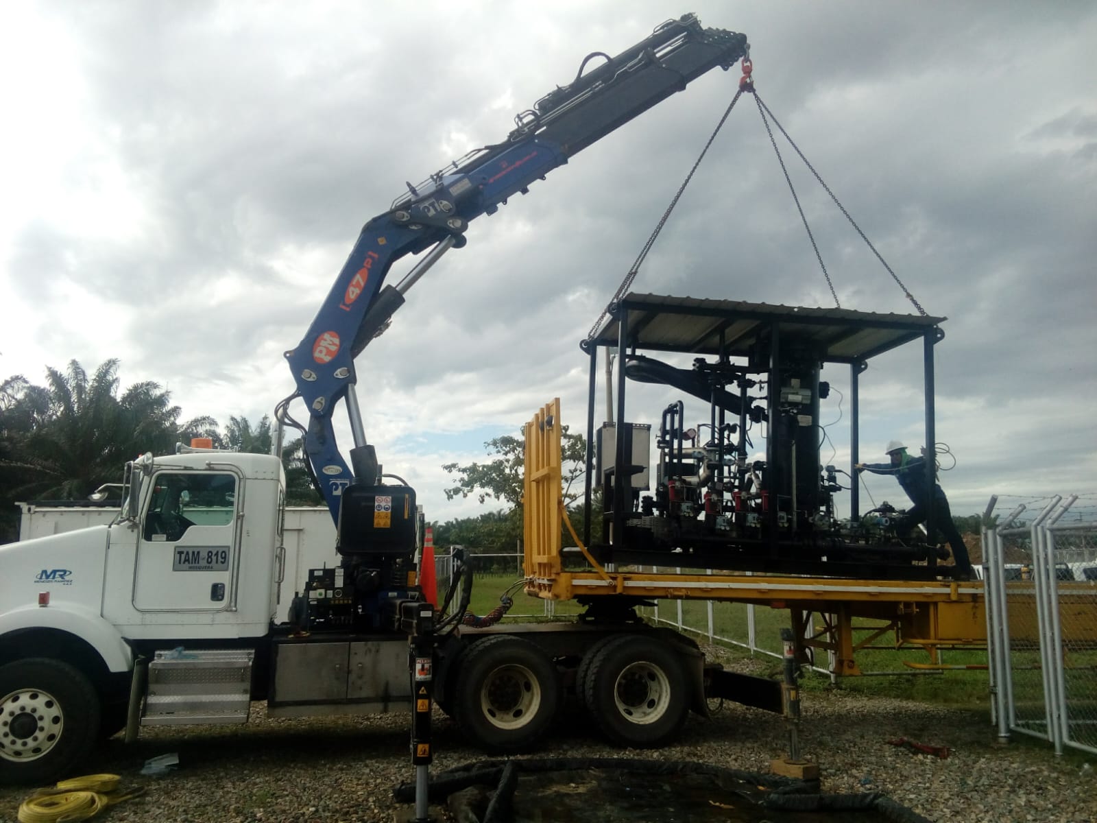 Grúa de brazo articulado izando equipos industriales